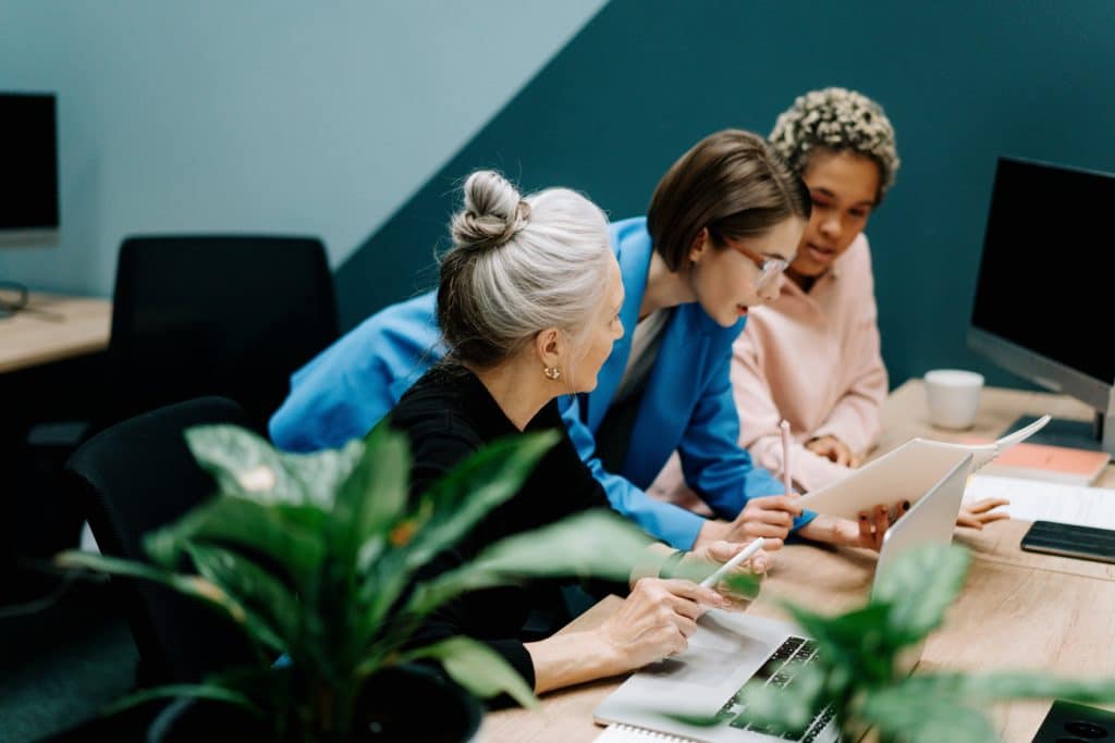 group of people working around a laptop